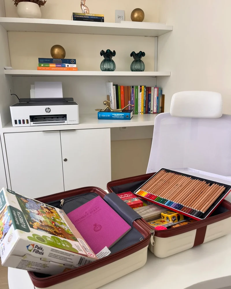 Consultório de psicologia com estante e materiais de estimulação cognitiva